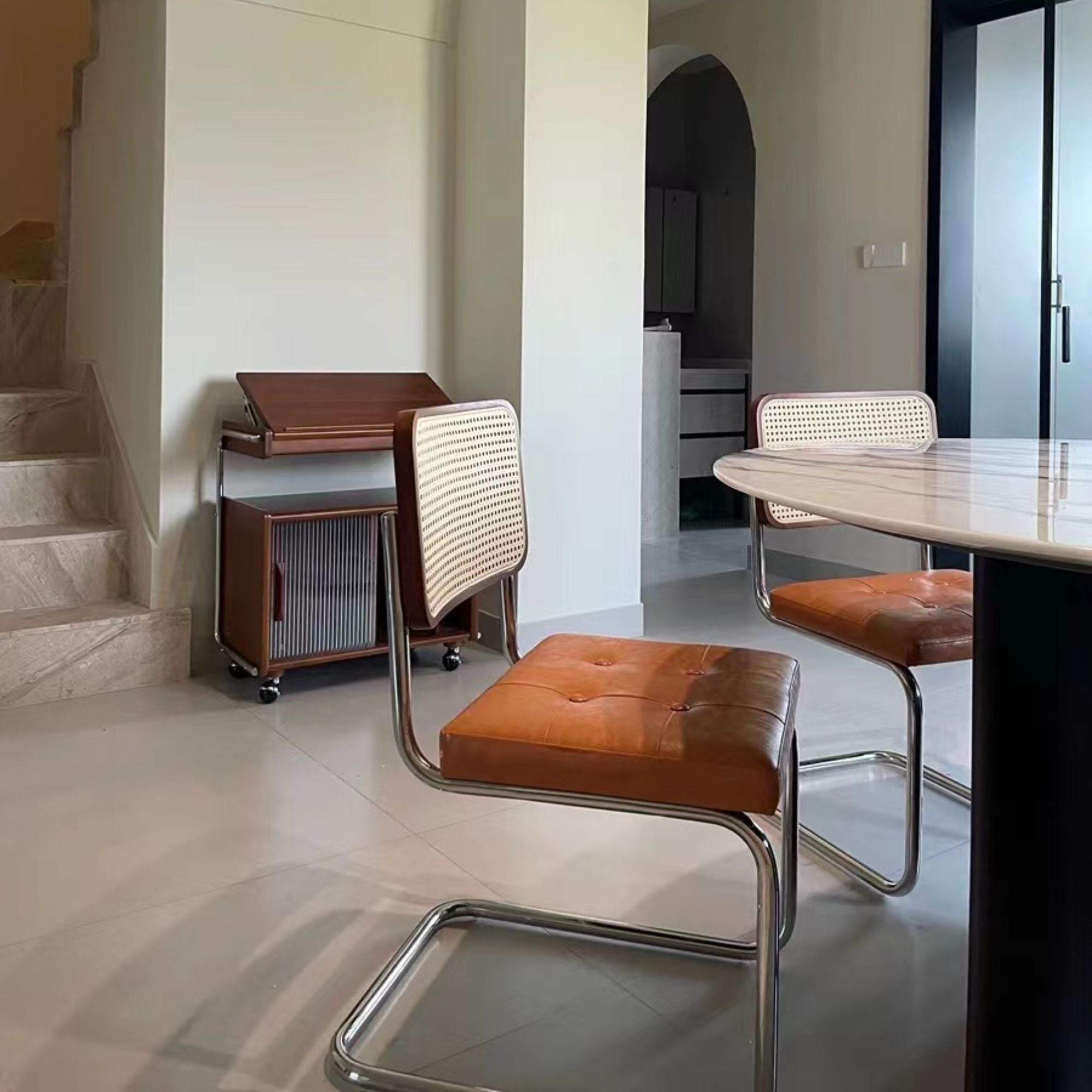 Zephyr stainless steel chair in front of circular dining table