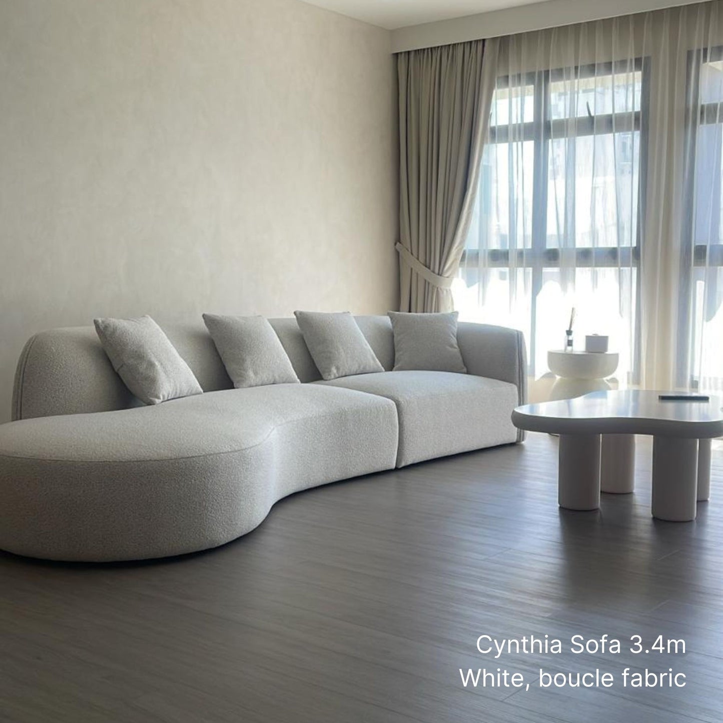 340cm 5 seater white boucle curved sofa in a modern living room with large windows and a coffee table.