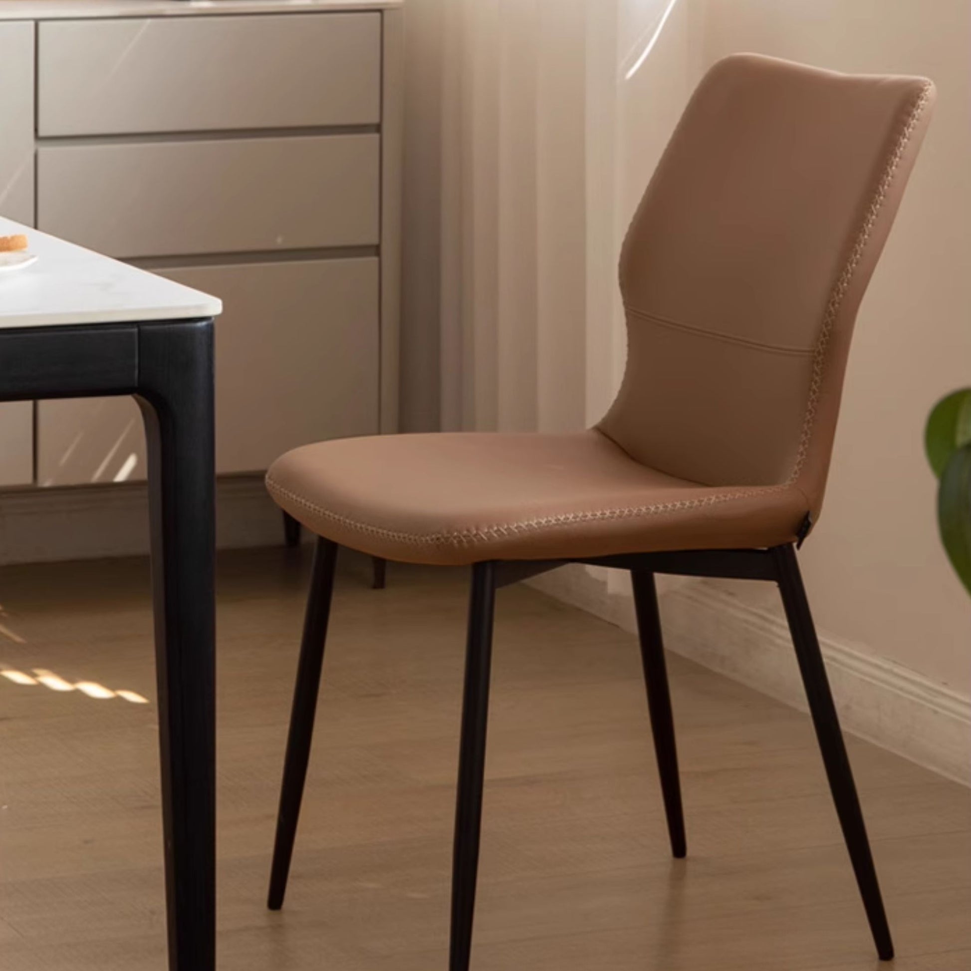 Brown chair with black legs in a room setting