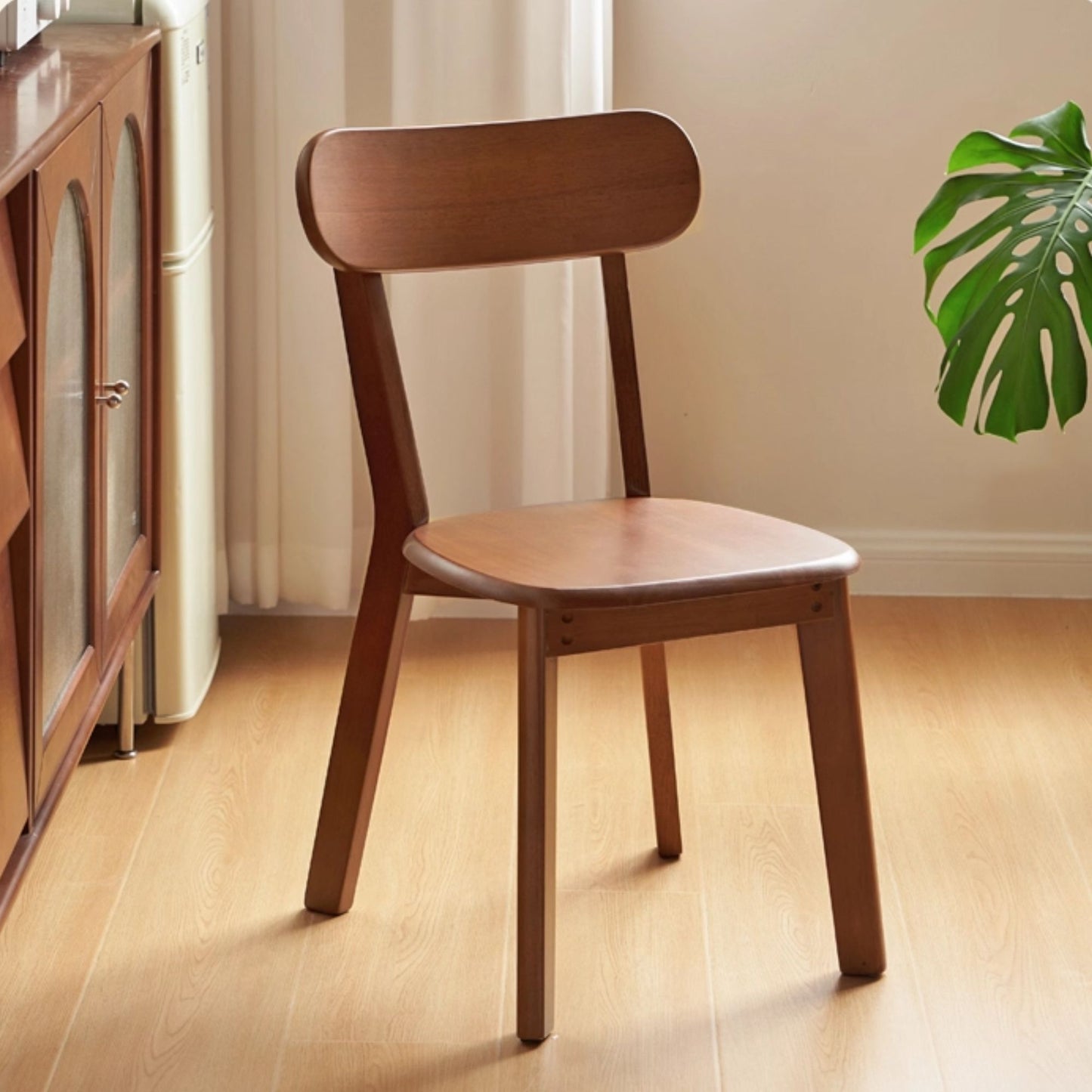 Wooden chair in a room with a plant and cabinet