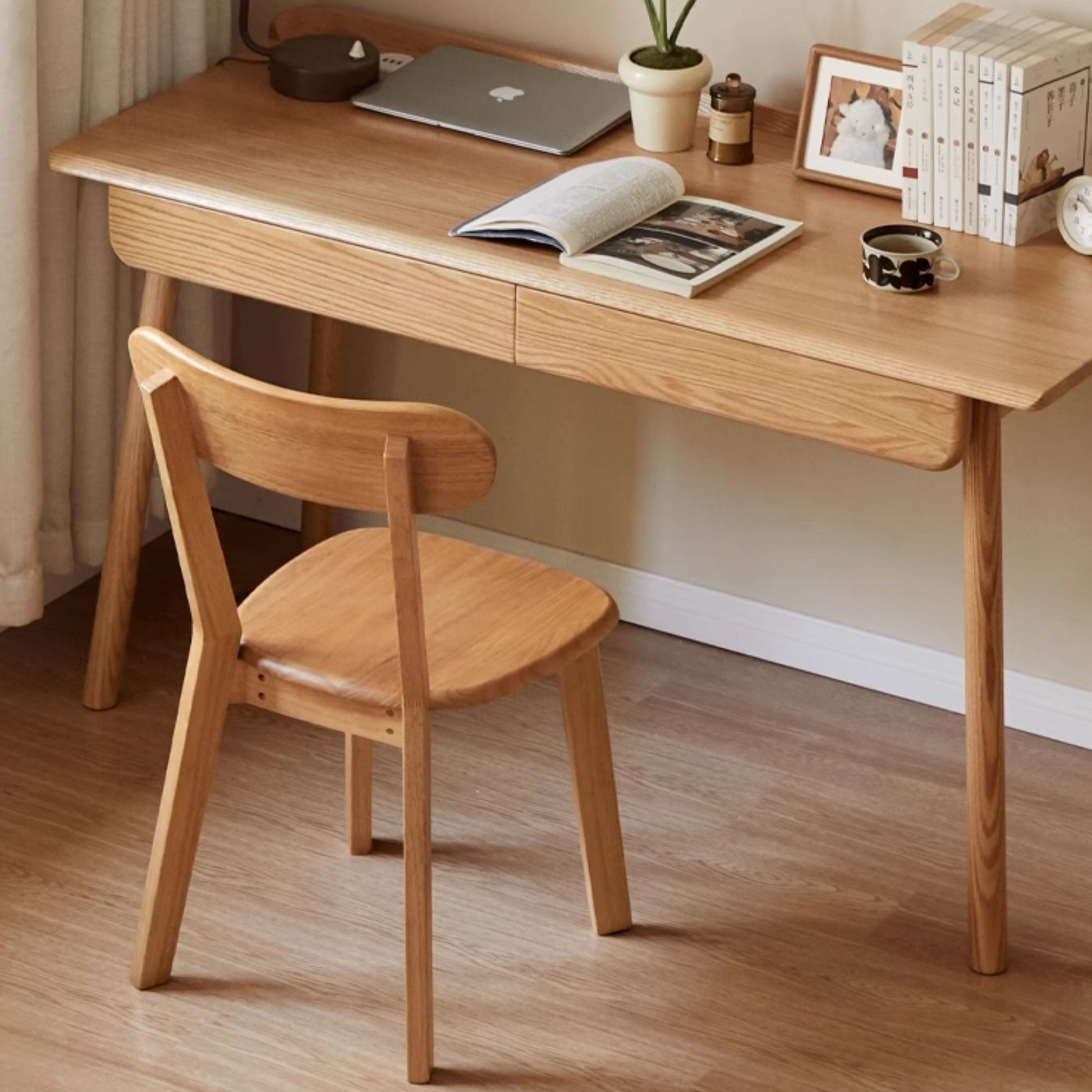 Wooden desk with chair, laptop, and books in a home office setting.