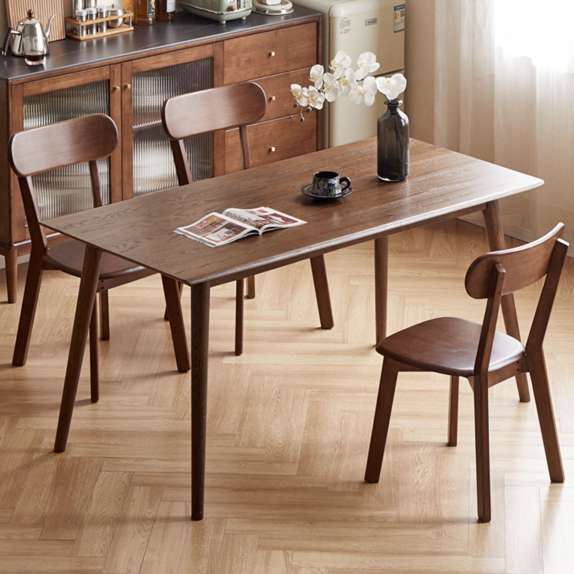 Wooden dining table with chairs in a room with wooden flooring.