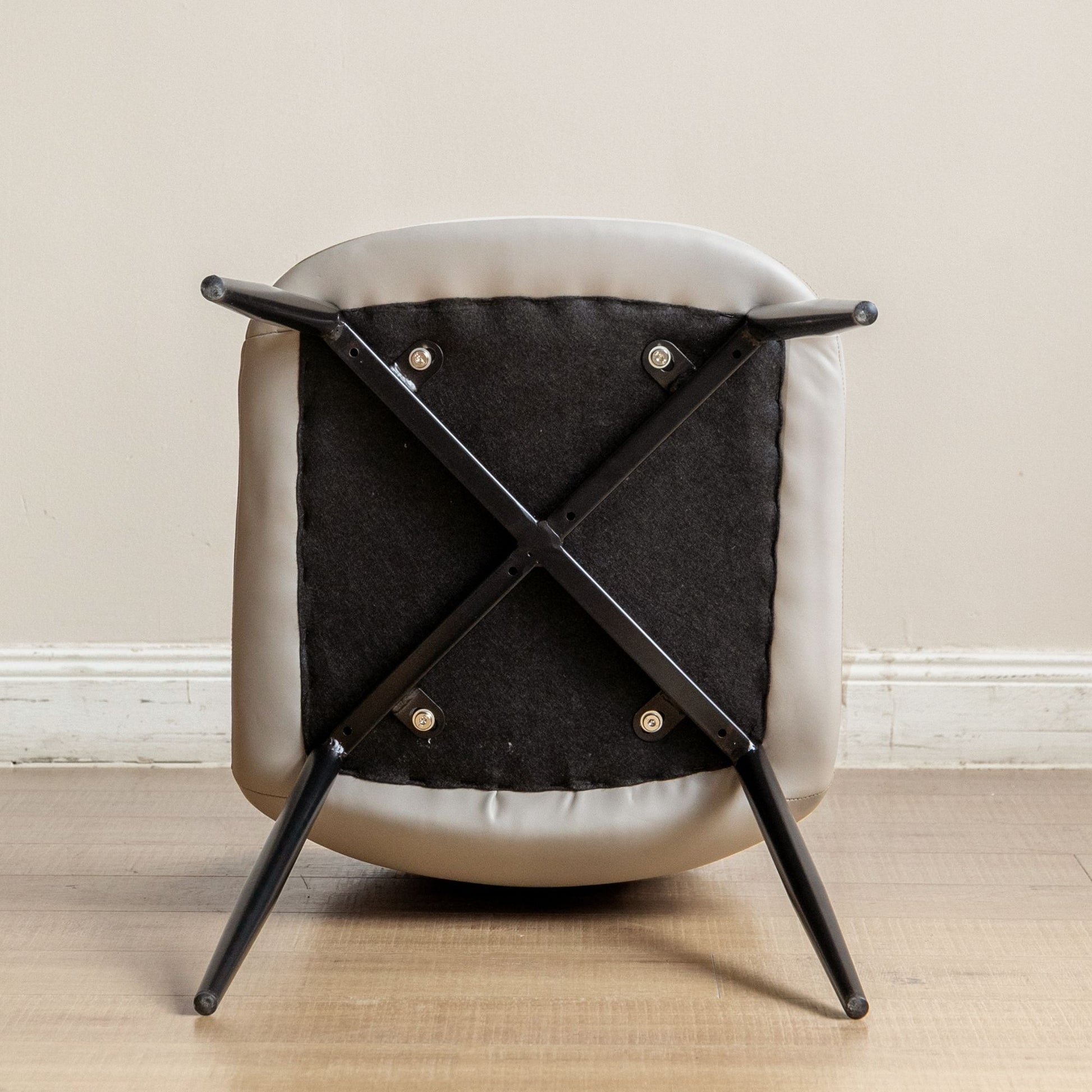 Chair with black metal frame and cushioned seat on a wooden floor.