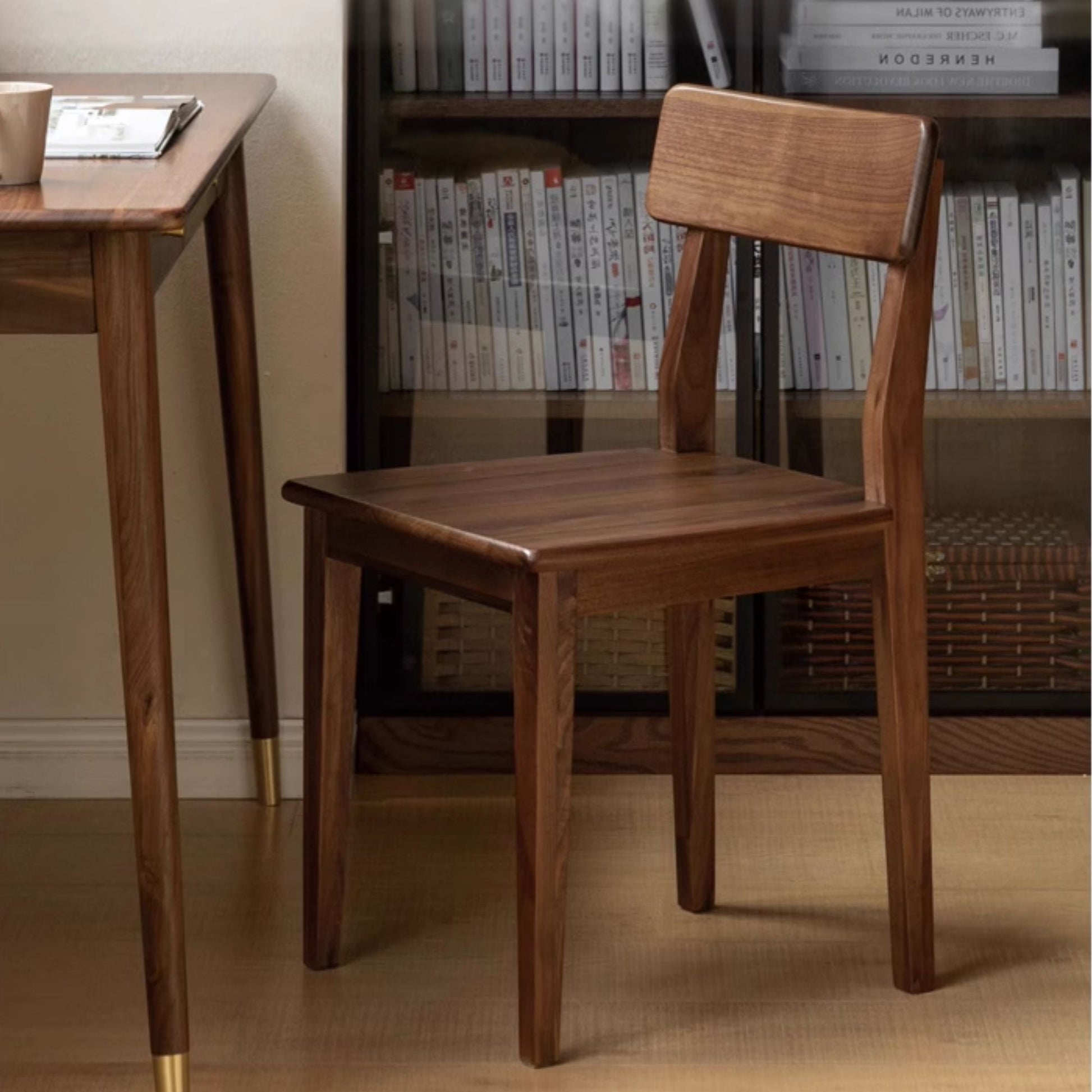 Wooden chair in a room with a bookshelf and table.