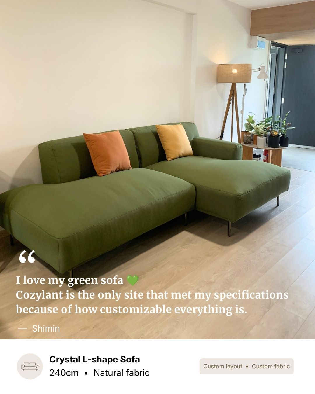An olive green L-shaped sectional sofa with two accent pillows in orange and yellow, shown in a modern living room setting with light wood floors and a floor lamp.