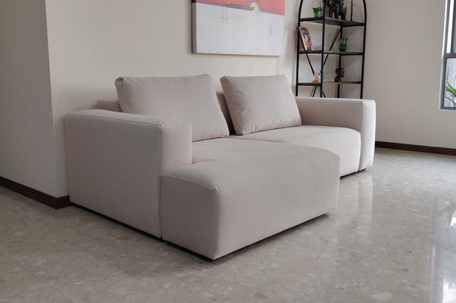L-shaped Cubix sectional in beige pet friendly fabric with plain seams in living room with beige marble floors