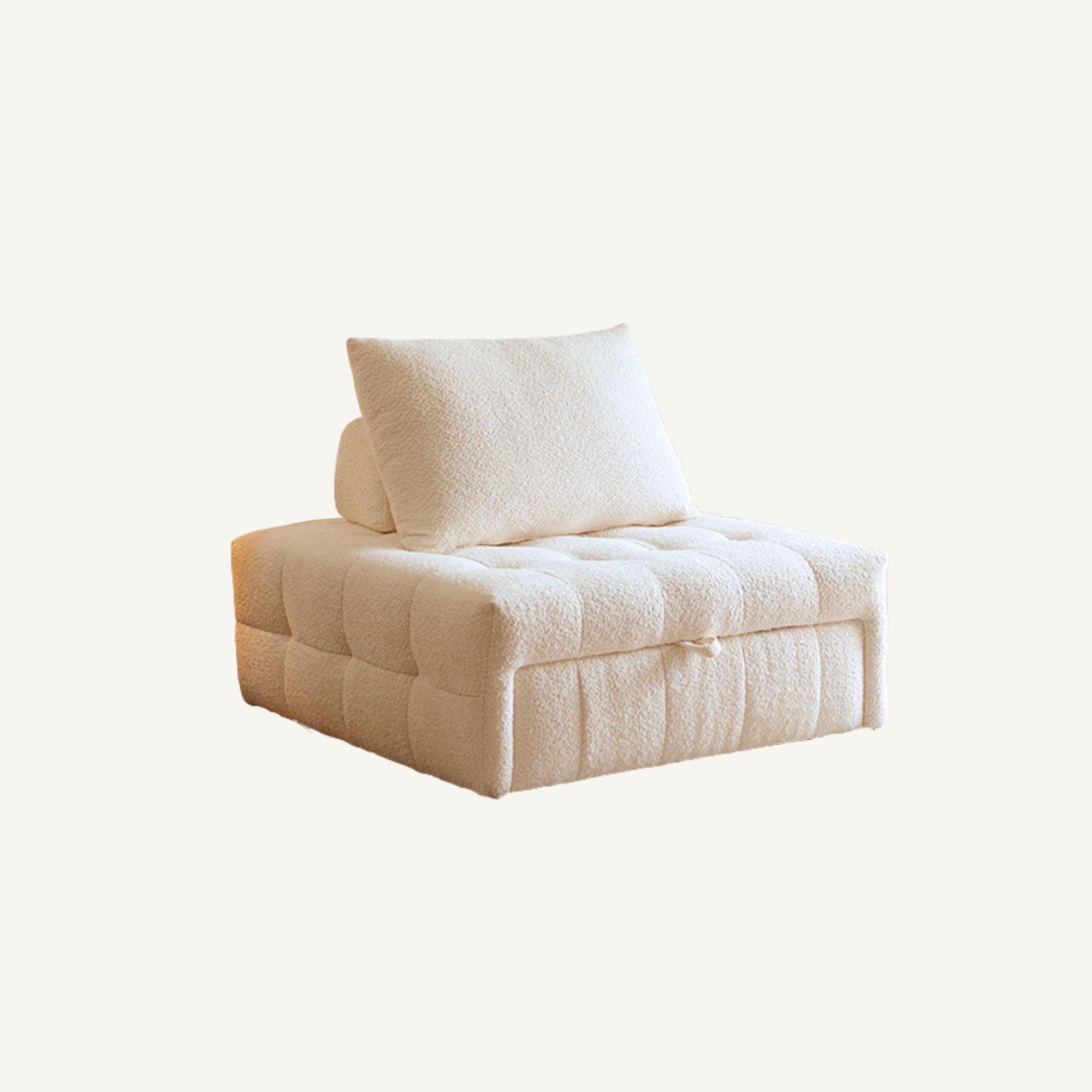 A cream-colored tufted sofa bed with a matching textured throw pillow, shown against a plain off-white background.