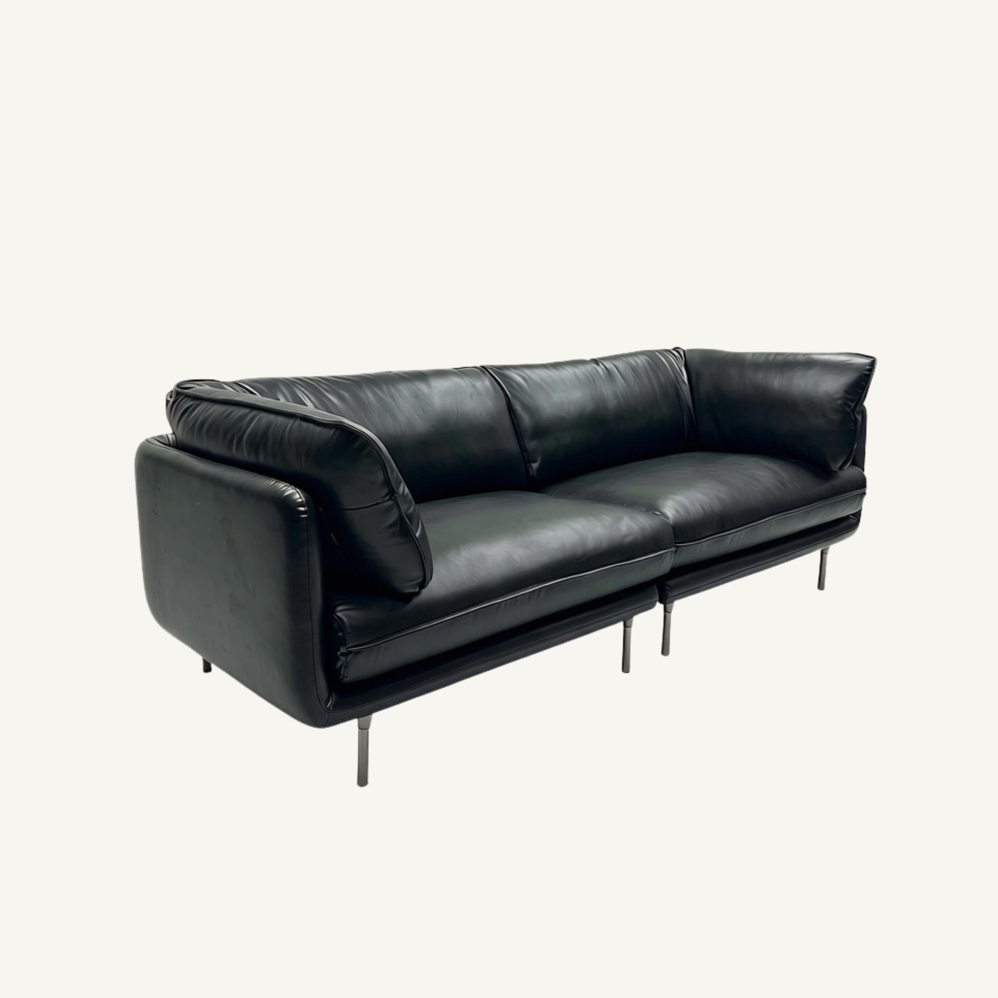 A modern black leather three-seater sofa with slim metal legs, photographed against a plain off-white background.