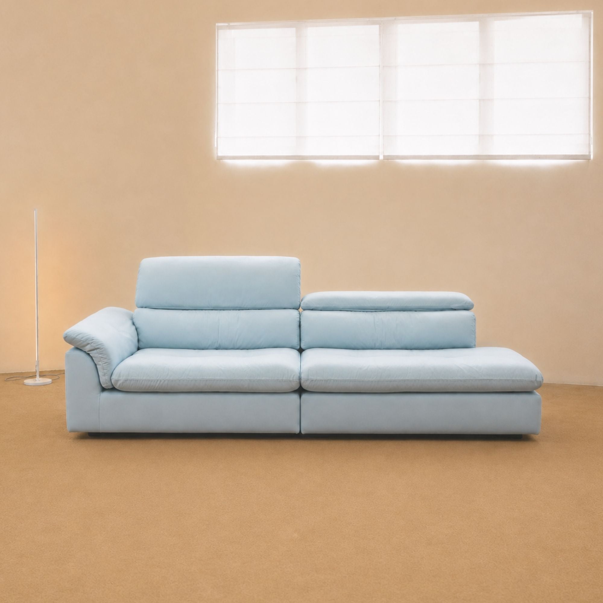 Light blue Calla One Arm Sofa with deep seats, a curved arm cushion and adjustable backrests shown at two heights at factory