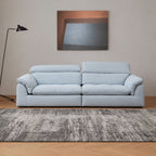 calla fabric adjustable backrest sofa in blue pet friendly fabric in a living room with grey rug and beige wall, a black lamp on the side