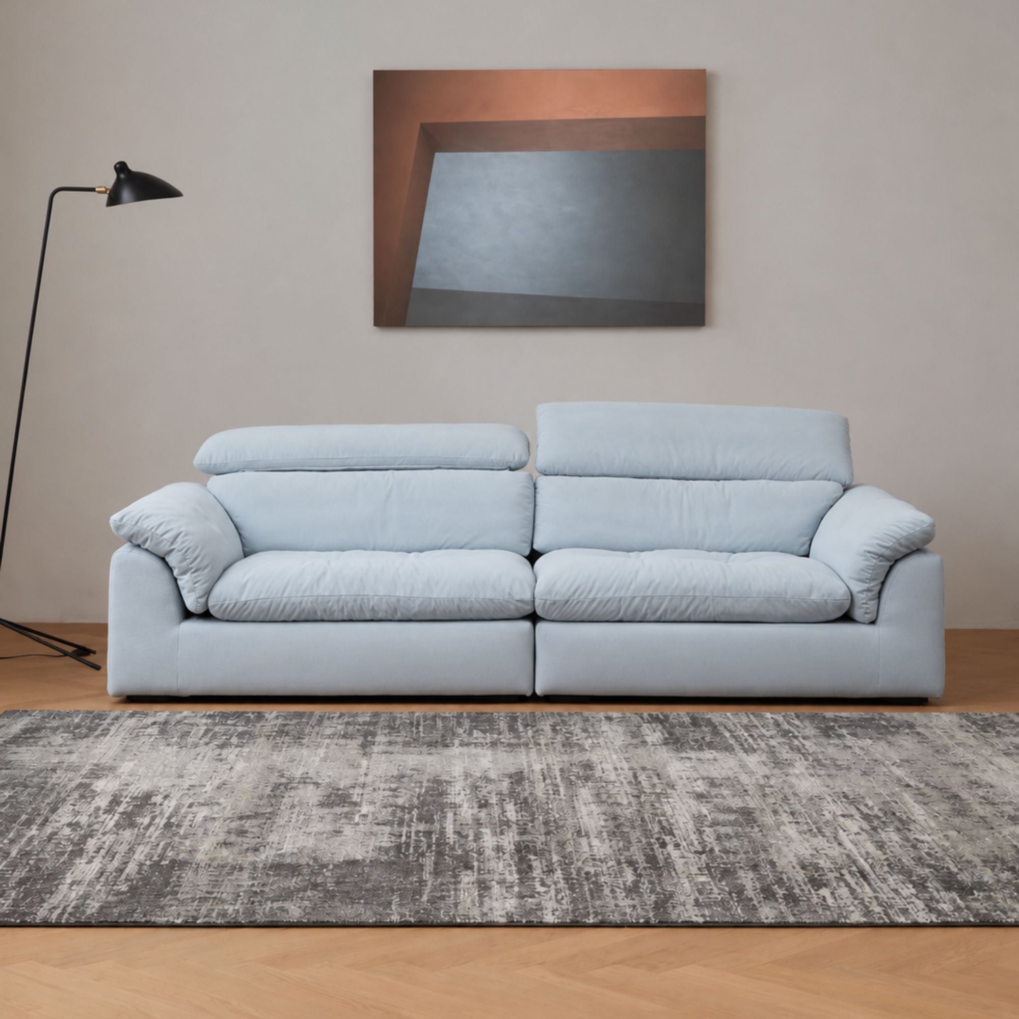 calla fabric adjustable backrest sofa in blue pet friendly fabric in a living room with grey rug and beige wall, a black lamp on the side