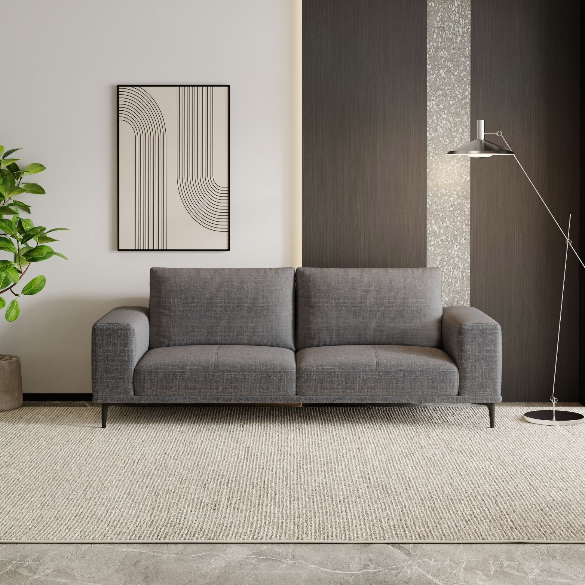 Gray sofa in a modern living room with a plant and wall art.