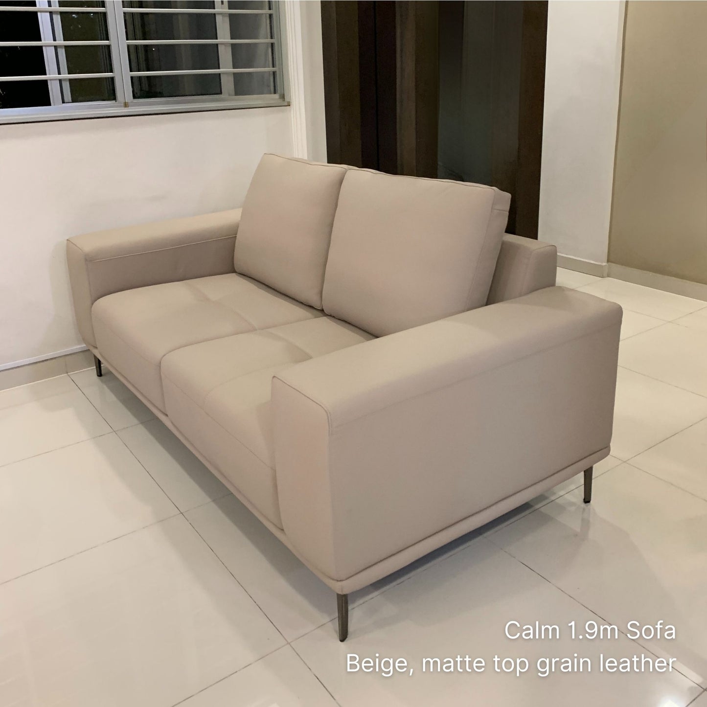 Beige sofa in a room with tiled floor and window