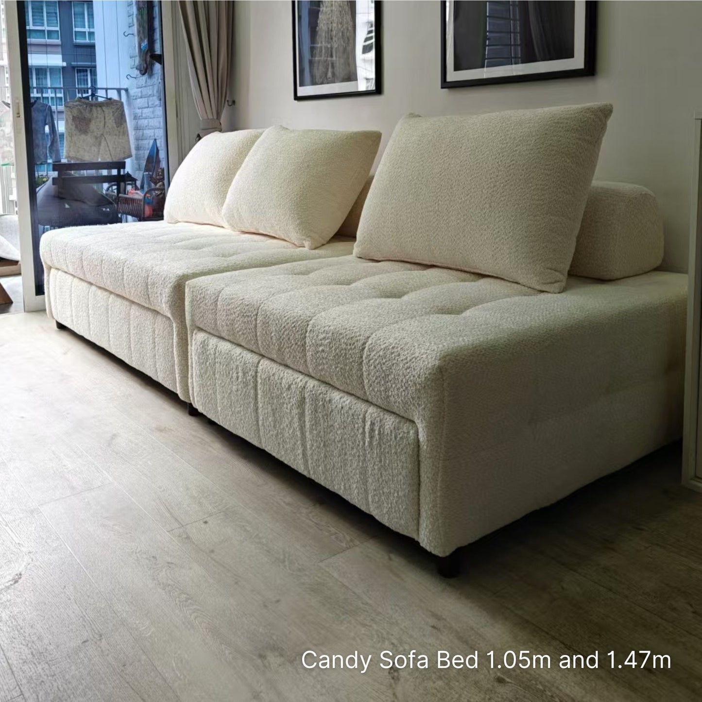 2 sets of white sofa bed in a room with wooden flooring and framed pictures on the wall.