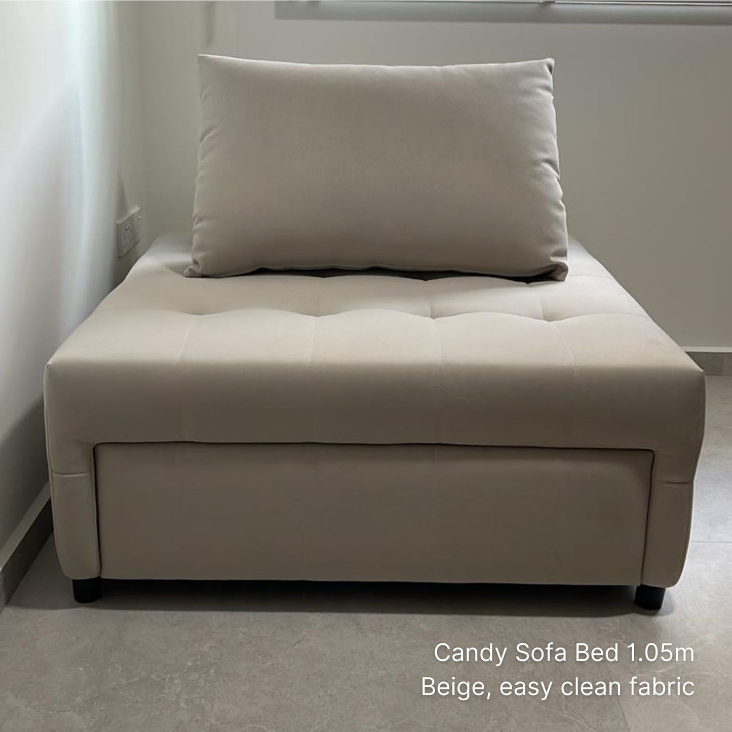 Beige sofa bed with a pillow on a plain background