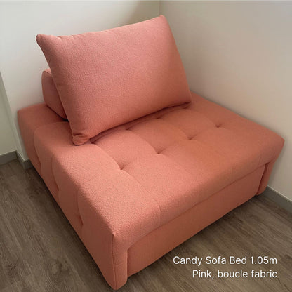 Pink sofa bed with boucle fabric in a corner of a room.