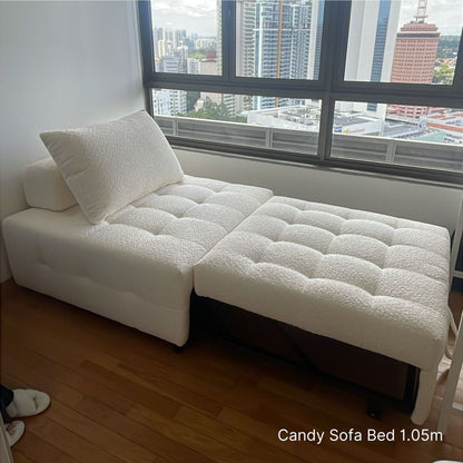 White sofa bed in a room with large windows showing a cityscape.
