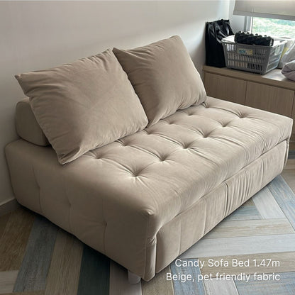 Beige sofa bed with pillows in a room setting