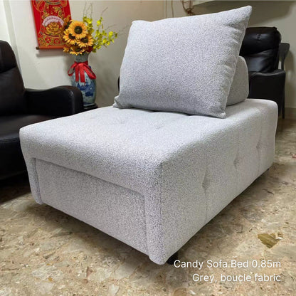 Gray boucle fabric sofa bed in a room setting with flowers and a calendar.
