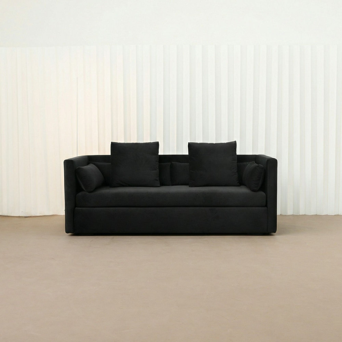 Black Casa sofa against a plain wall with a neutral floor.