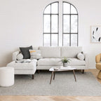 Modern living room with a light gray sectional sofa, coffee table, and decorative pillows.