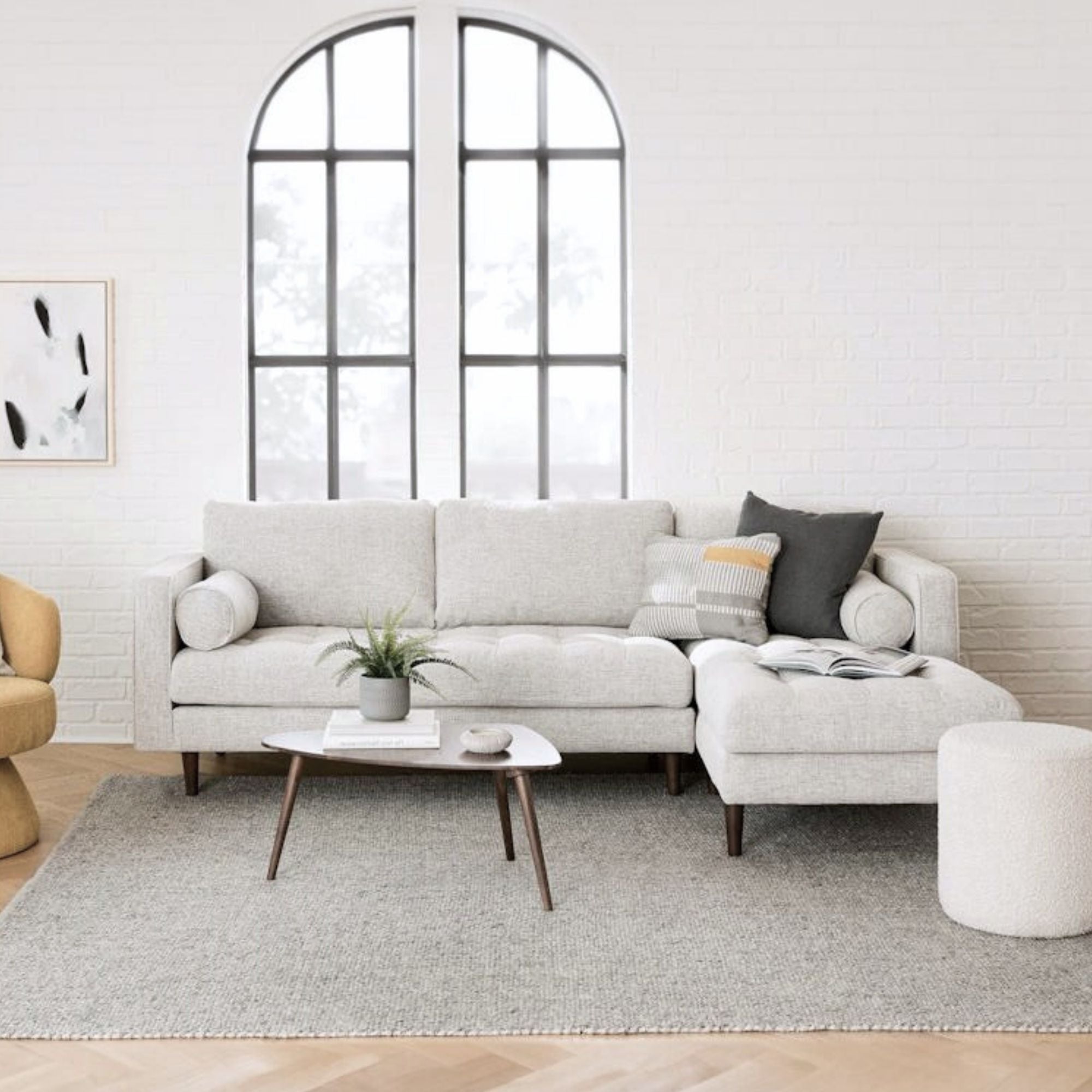 Modern living room with a gray sectional sofa, coffee table, and decorative items.