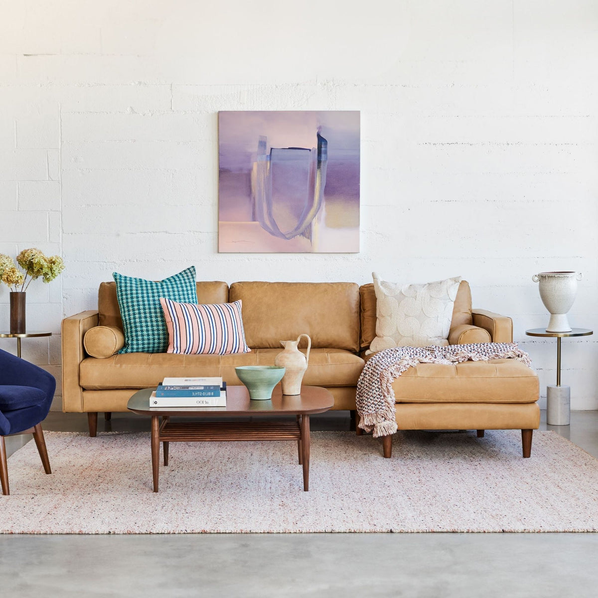 Living room with a tan sectional sofa, colorful pillows, and a coffee table.