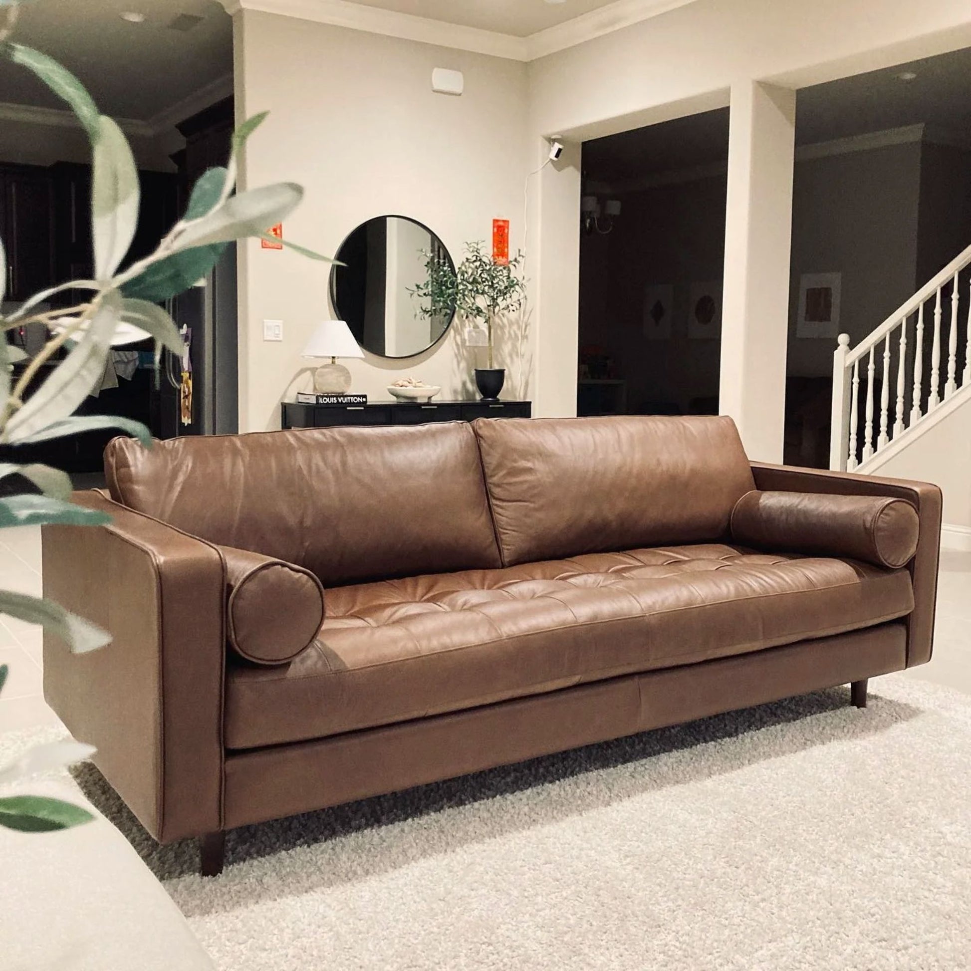 Brown leather sofa in a living room setting with decor elements.