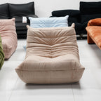 Beige cushioned lounge chair in a room with other colorful lounge chair and sofa