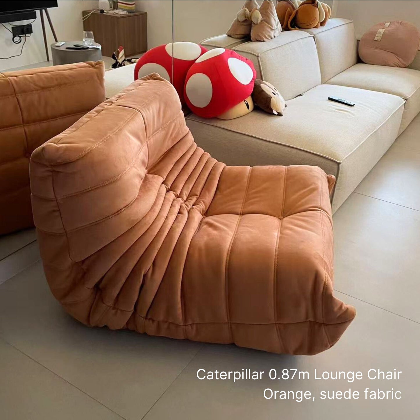 Orange caterpillar lounge chair in a living room setting with other furniture.