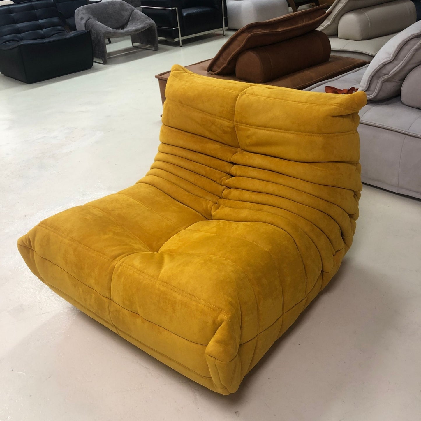Yellow lounge chair in a room with other furniture.