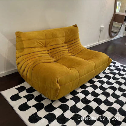 Yellow 131cm 2 seater Caterpillar sofa on a black and white patterned rug