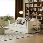 Celeste fabric sofa in whtie with rug, side table, plant and bookshelf at the back