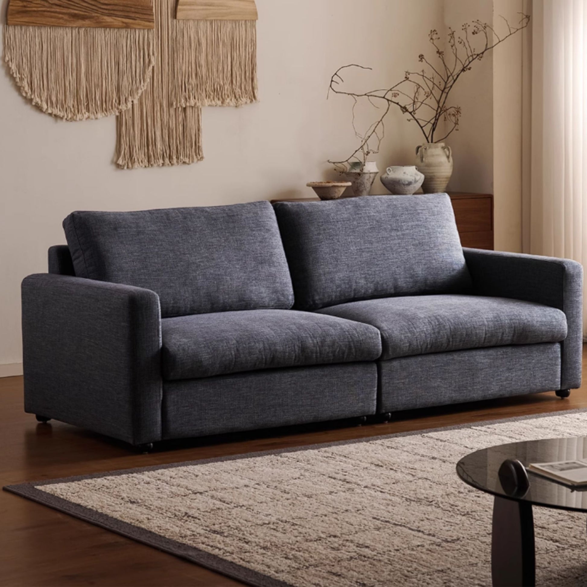 Gray sofa in a living room with decorative elements and a rug.