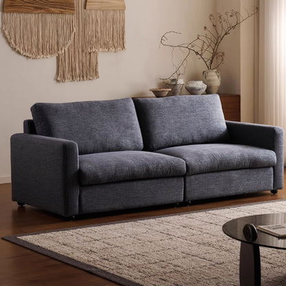 Gray sofa in a living room with decorative elements and a rug.