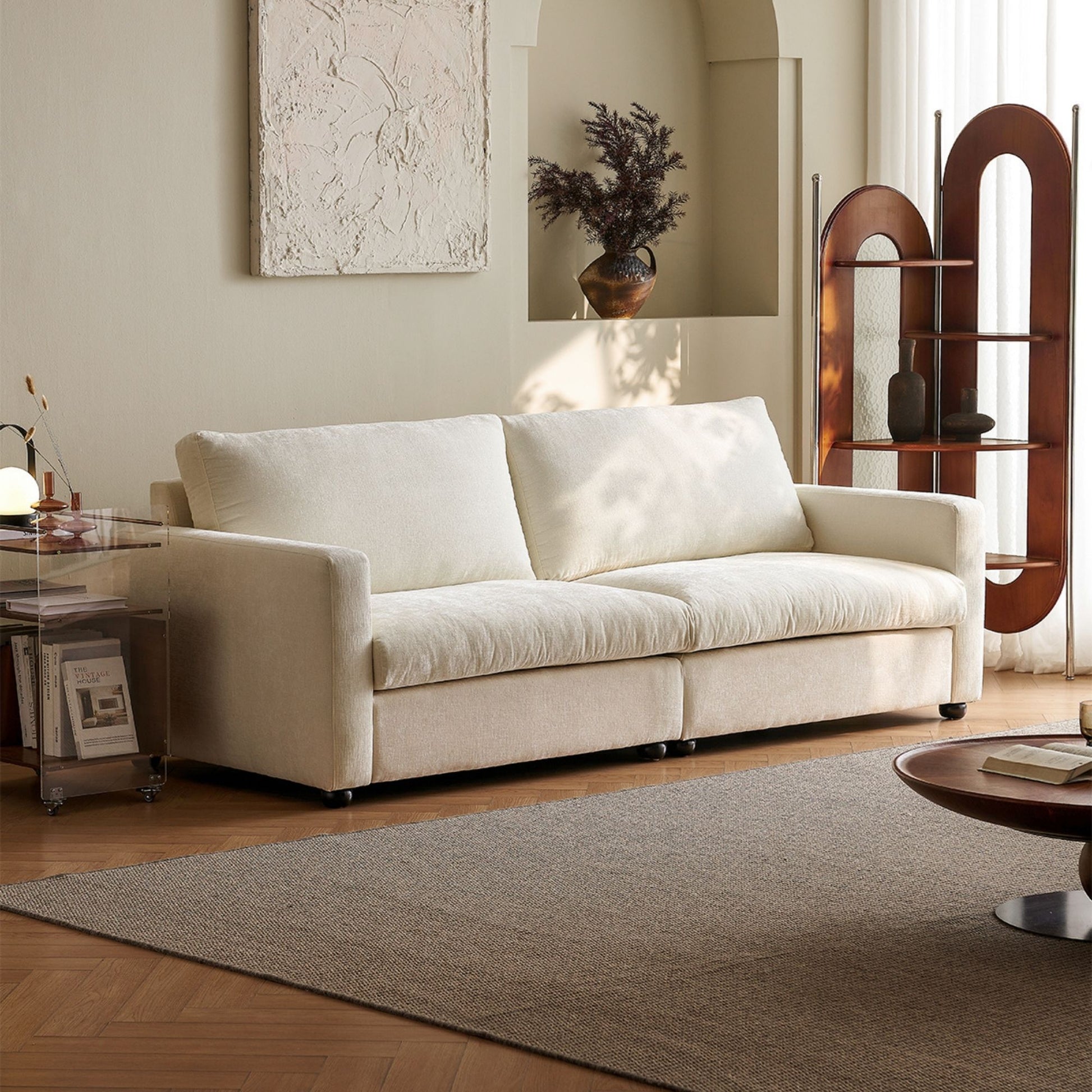 White Chalet fabric sofa in a living room with a rug, coffee table, and decorative items.