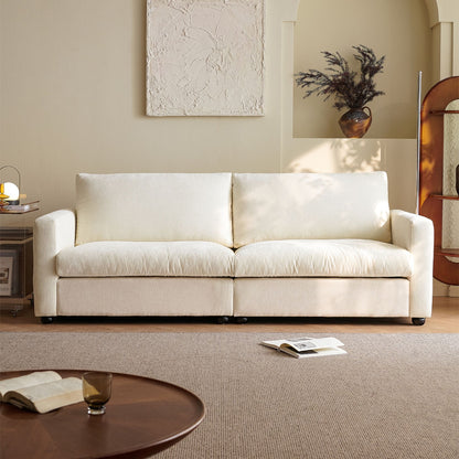 White sofa in a living room with a round coffee table and books.