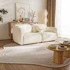 Modern living room with a white sofa, wooden coffee table, and decorative items.