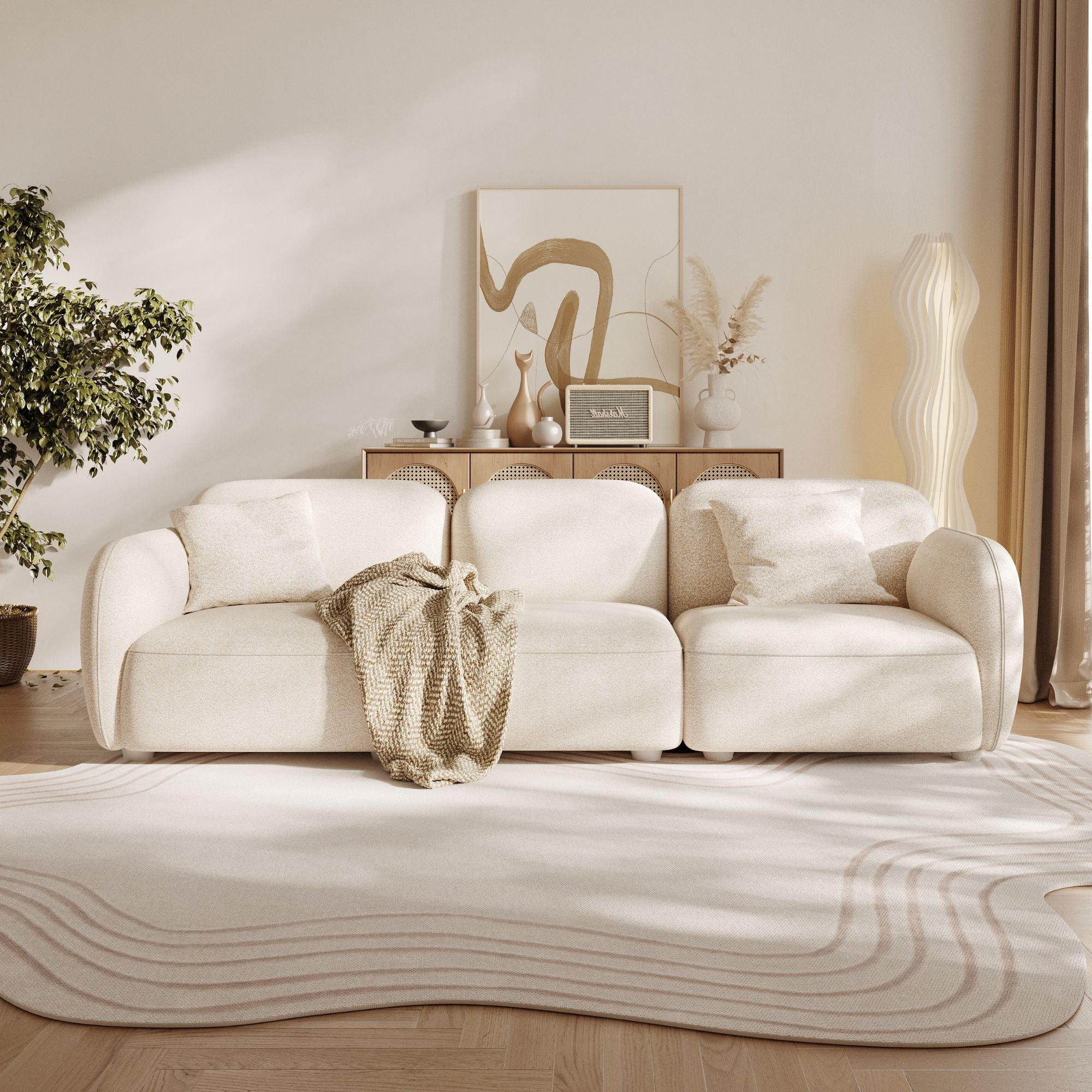 Modern living room with a beige sofa, decorative items, and a plant.