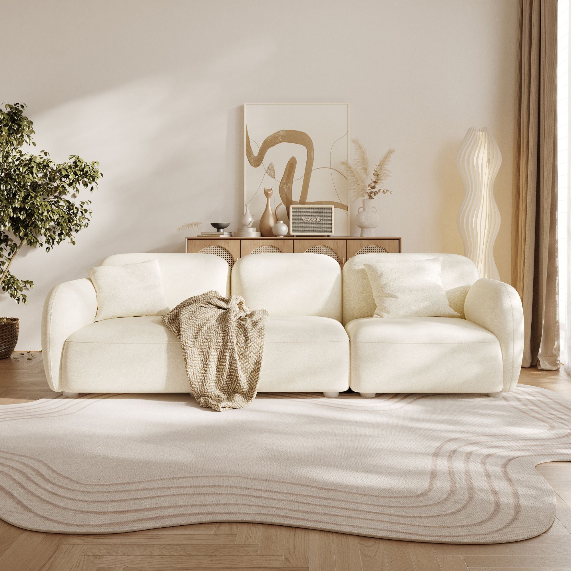 Modern living room with a white sofa, decorative rug, and wall art.