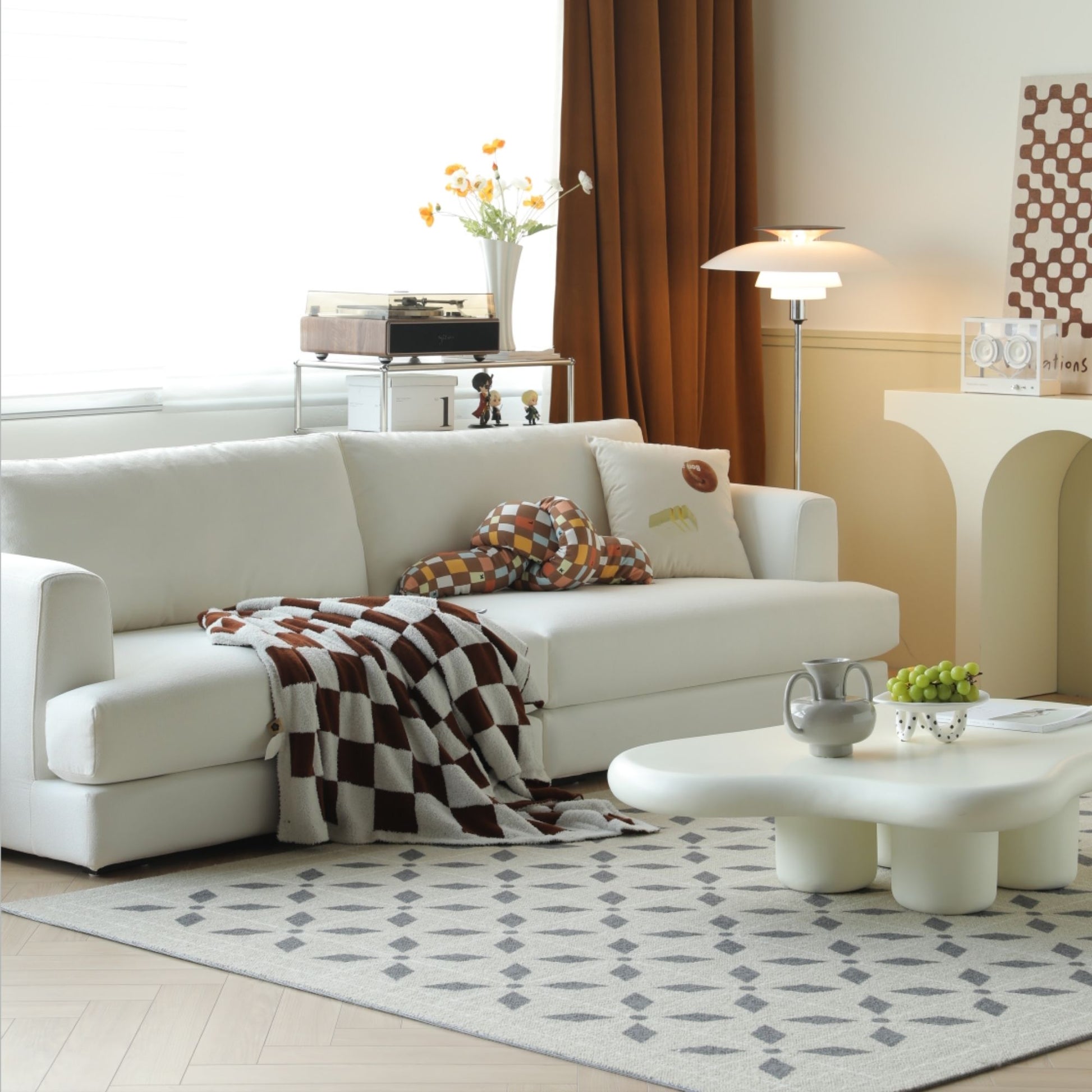 Modern living room with a white sofa, coffee table, and decorative items.