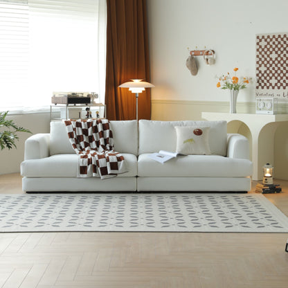 White sofa with a checkered blanket in a living room setting