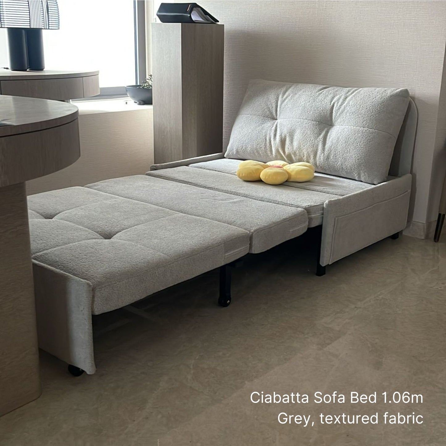 Gray sofa bed with textured fabric in a room setting