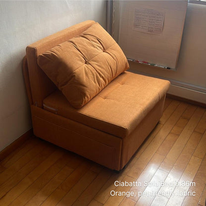 Orange sofa bed against a wall with a wooden floor