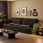 Living room with a green sofa, coffee table, and wall art.