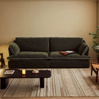 Green sofa in a living room with a coffee table and decorative items.