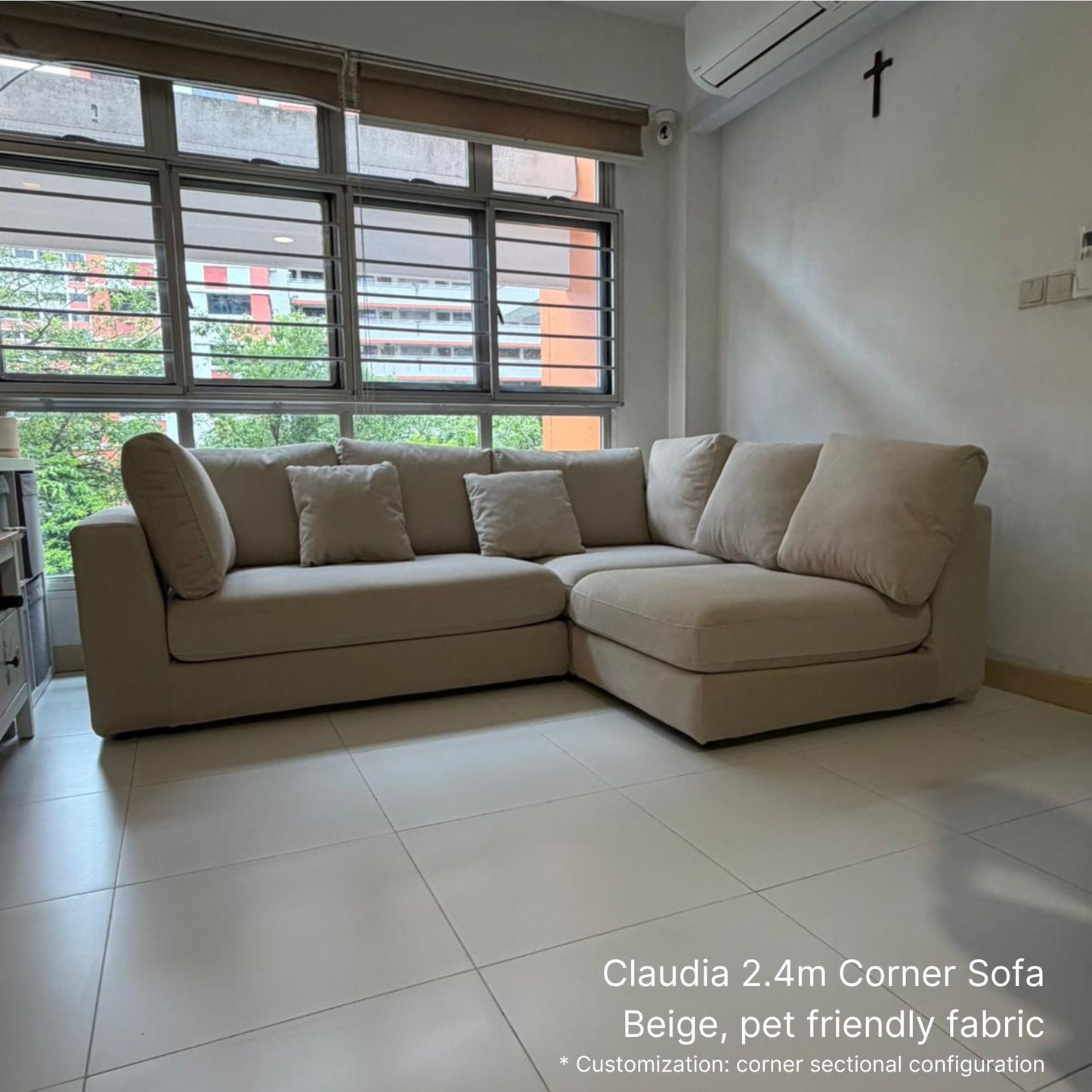 Beige corner sofa in a living room with large windows.