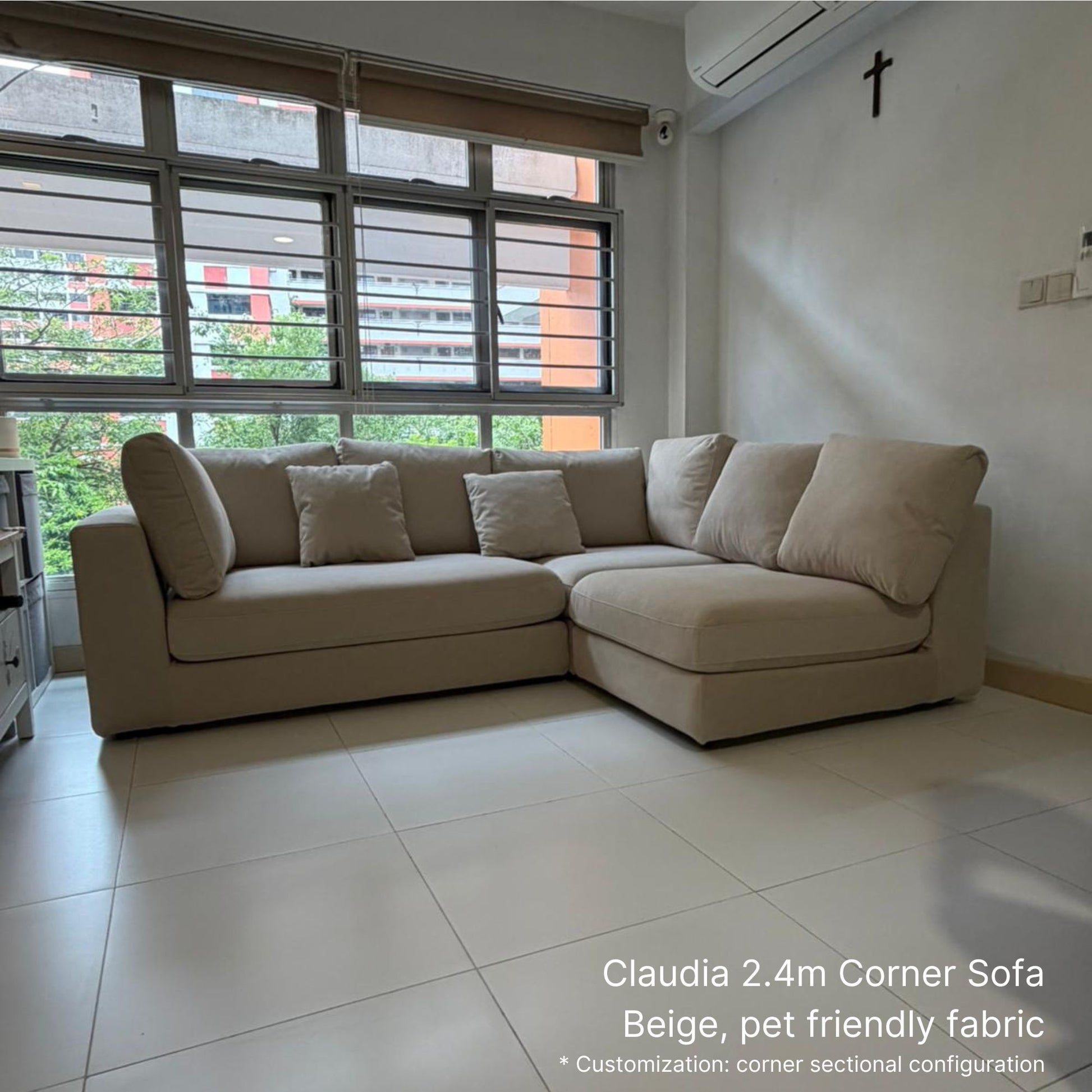 Beige corner sofa in a living room with large windows.