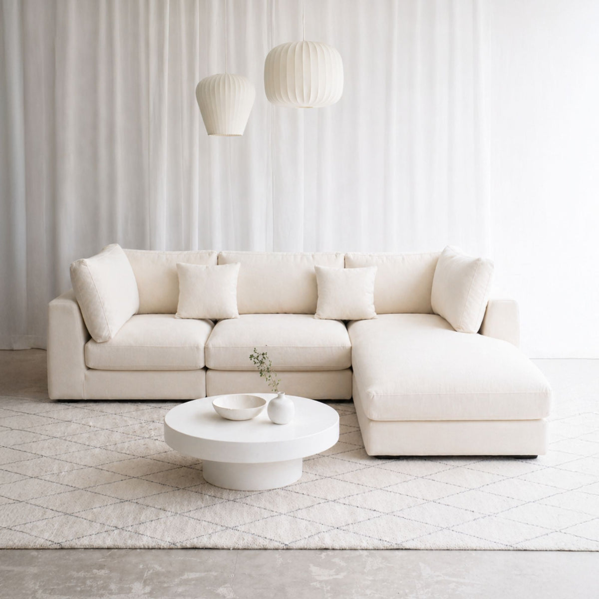 Claudia L-shaped sectional sofa with right chaise in living room with rug underneath