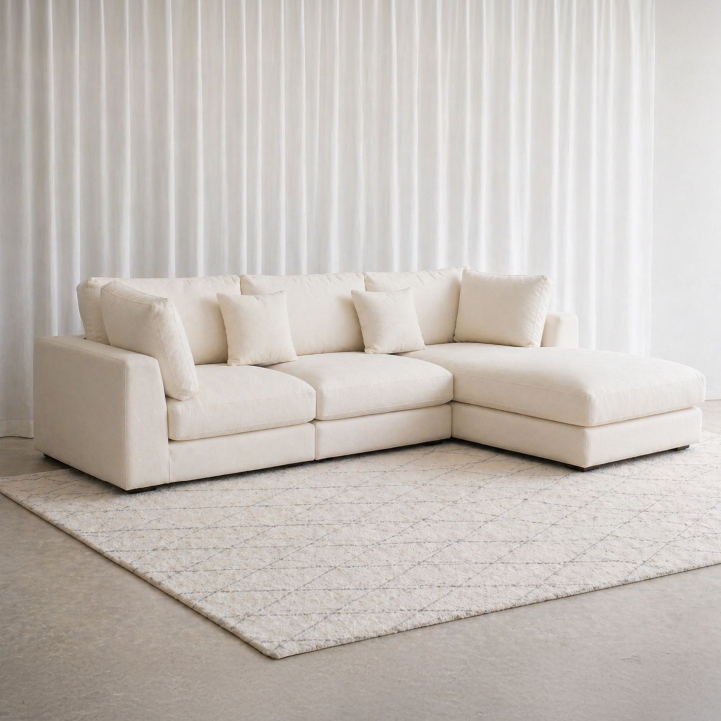 White sectional sofa in a room with light-colored walls and rug.